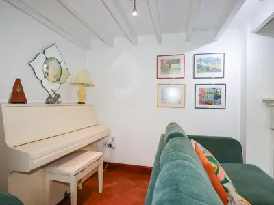 a living room with a piano and a green couch at Rosemaddon in Newquay