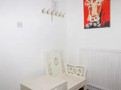 a white bench in a room with a painting on the wall at Rosemaddon in Newquay