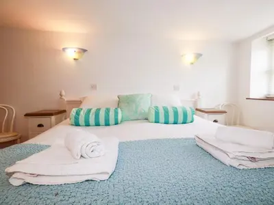a bedroom with a large white bed with towels on it at Rosemaddon in Newquay