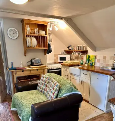 a living room with a couch in a kitchen at Culloden Farmhouse in Camelford