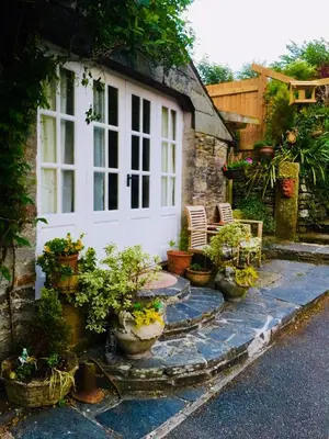 a house with potted plants on the side of it at Culloden Farmhouse in Camelford