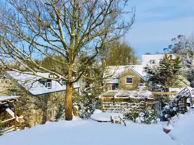 a house with a tree in the snow at Culloden Farmhouse in Camelford