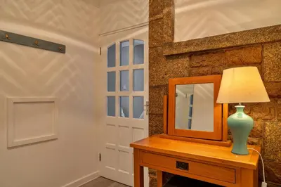 a table with a mirror and a lamp on a dresser at Finest Retreats - No 5 Harlequin in St Ives