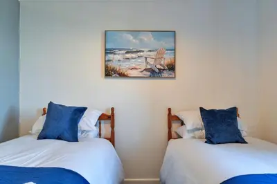 two beds in a room with a picture on the wall at Finest Retreats - No 5 Harlequin in St Ives