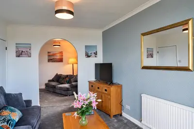 a living room with a couch and a tv on a table at Finest Retreats - No 5 Harlequin in St Ives