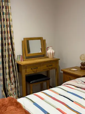 a bedroom with a desk with a mirror and a bed at Acorn Lodge Pentewan in St Austell
