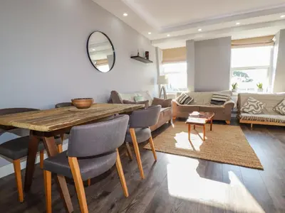 a living room with a wooden table and chairs at Priory in St Austell