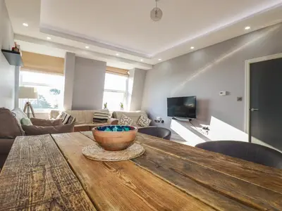 a living room with a wooden table with a bowl on it at Priory in St Austell