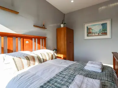 a bedroom with a bed and a wooden headboard at Priory in St Austell