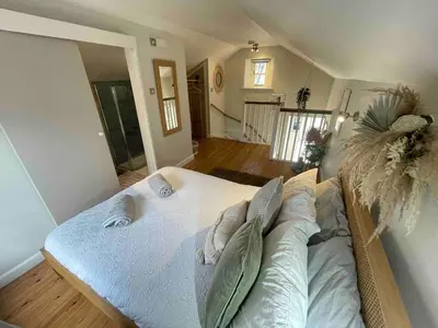 a large bed with pillows on it in a room at Gorgeous cottage for couples & small families in Saint Columb Minor