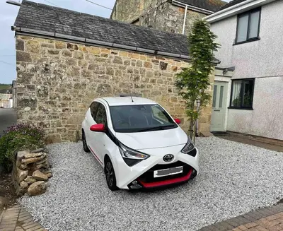 a white car parked in front of a house at Gorgeous cottage for couples & small families in Saint Columb Minor