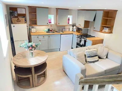 a living room with a couch and a table in a kitchen at Gorgeous cottage for couples & small families in Saint Columb Minor