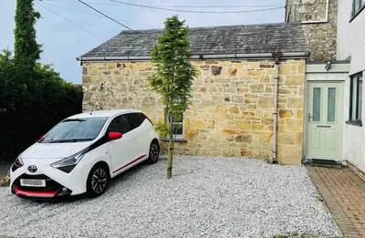 a white car parked in front of a house at Gorgeous cottage for couples & small families in Saint Columb Minor