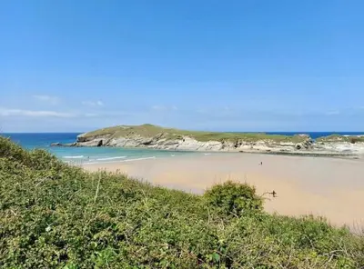 a view of a beach with an island in the ocean at Gorgeous cottage for couples & small families in Saint Columb Minor