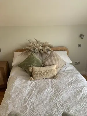 a bed with a bunch of pillows on it at Gorgeous cottage for couples & small families in Saint Columb Minor