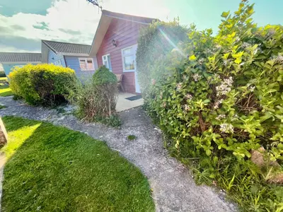 a house with a garden with grass and flowers at 5 Berth Chalet Holiday Apartment in Cornwall in Padstow