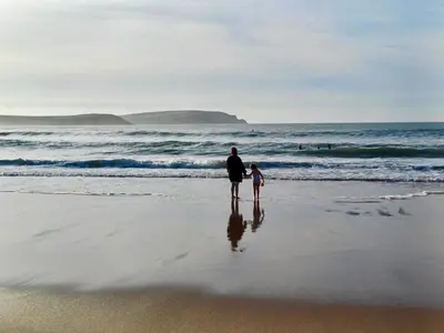 a man and a child standing on the beach at 5 Berth Chalet Holiday Apartment in Cornwall in Padstow