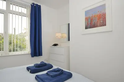 a bedroom with two blue towels on a bed at Falmouth Bay 2 in Falmouth