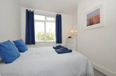 a bedroom with a bed with blue pillows on it at Falmouth Bay 2 in Falmouth