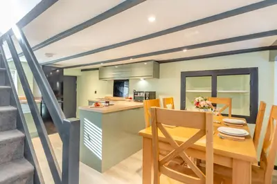 a kitchen and dining room with a wooden table and chairs at Lanreath Cottage with hot tub, The Vale, Cornwall in Looe