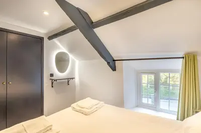 a bedroom with a bed and a window at Lanreath Cottage with hot tub, The Vale, Cornwall in Looe