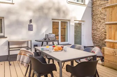 a table and chairs in a room with a table at Lanreath Cottage with hot tub, The Vale, Cornwall in Looe