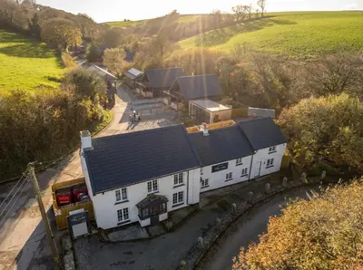 an aerial view of a white house in the countryside at Lanreath Cottage with hot tub, The Vale, Cornwall in Looe