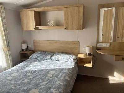a bedroom with a bed with a blue comforter at Two bedroom Holiday Home with countryside view in St Austell