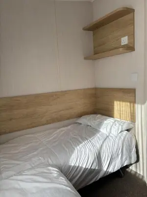 a bedroom with a bed with a wooden headboard at Two bedroom Holiday Home with countryside view in St Austell