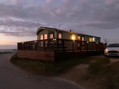 a small house with a car parked in front of it at Sunset Serenity in Perranporth