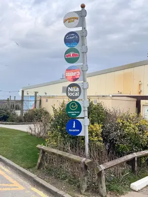 a street sign with many signs on a pole at Sunset Serenity in Perranporth