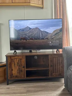 a flat screen tv sitting on top of a wooden entertainment center at Sunset Serenity in Perranporth