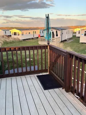a deck with a view of a group of mobile homes at Sunset Serenity in Perranporth