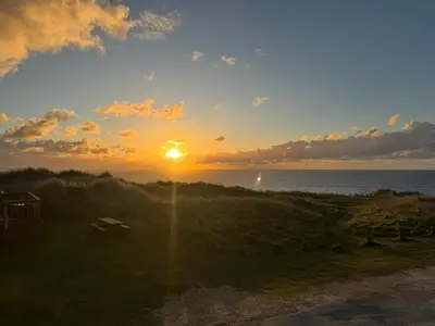 a sunset over the ocean with the sun in the sky at Sunset Serenity in Perranporth