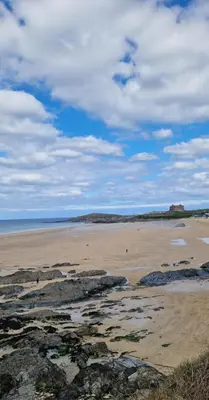 a beach with rocks and the ocean on a cloudy day at HolidayLet 24 Bude Newperran Holiday Park in Cubert