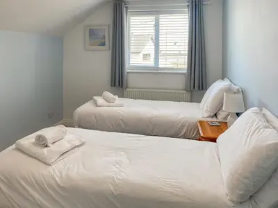 a bedroom with two beds with towels on them at Chy An Mordros in Hayle