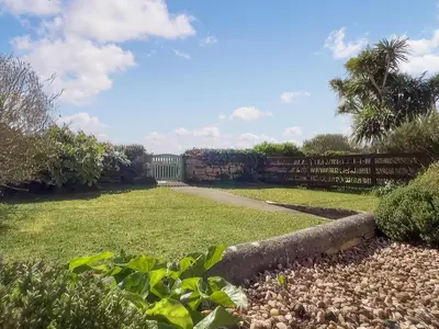 a garden with a fence and a pathway at Chy An Mordros in Hayle