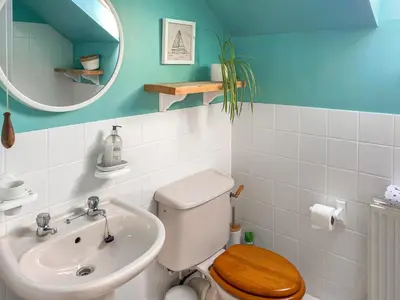 a bathroom with a toilet and a sink and a mirror at Chy An Mordros in Hayle
