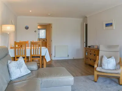 a living room with a couch and a dining room at Camelside in Wadebridge