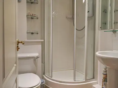 a bathroom with a shower and a toilet and a sink at Camelside in Wadebridge
