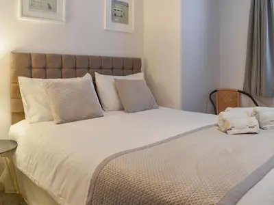 a bedroom with a large bed with white sheets and pillows at Camelside in Wadebridge