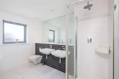 a white bathroom with a sink and a toilet at 14 Azure in Fistral, Newquay in Newquay