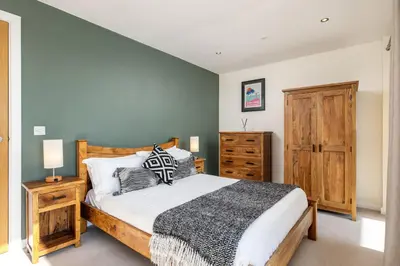 a bedroom with a large bed and a dresser at 14 Azure in Fistral, Newquay in Newquay