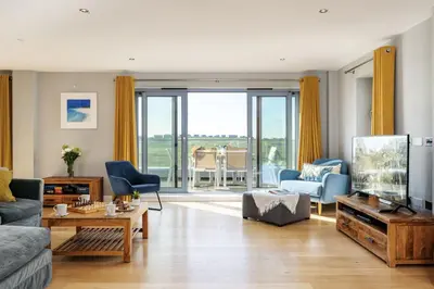 a living room with a couch and a tv at 14 Azure in Fistral, Newquay in Newquay