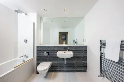 a bathroom with a sink and a toilet and a mirror at 14 Azure in Fistral, Newquay in Newquay