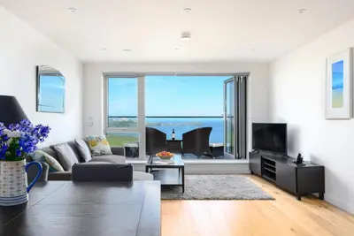 a living room with a couch and a tv at 32 One Lusty Glaze in Newquay in Newquay