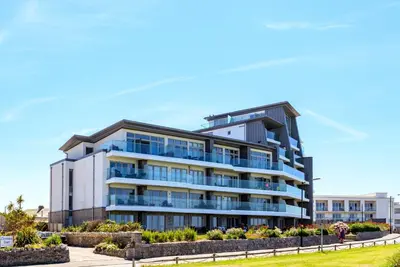 an apartment building with balconies on the beach at 32 One Lusty Glaze in Newquay in Newquay