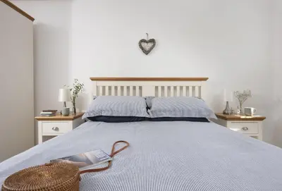 a bedroom with a bed with a basket on it at Ivy Chimney Cottage near Scorrier and close to Porthtowan in Porthtowan