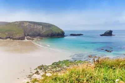 a view of a beach with rocks in the ocean at Ivy Chimney Cottage near Scorrier and close to Porthtowan in Porthtowan