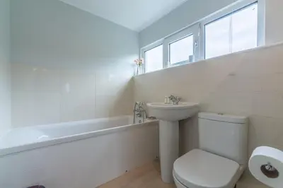 a bathroom with a toilet and a sink and a bath tub at Schoopers - Holiday Home in Rock in Padstow